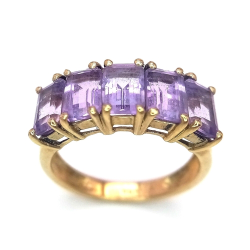 310 - A 9K GOLD RING WITH 5 AMETHYST STONES .  2.8gms   size L