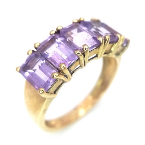 310 - A 9K GOLD RING WITH 5 AMETHYST STONES .  2.8gms   size L