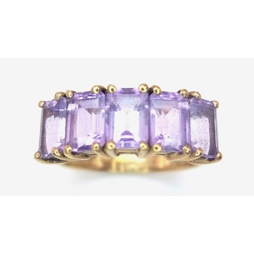 310 - A 9K GOLD RING WITH 5 AMETHYST STONES .  2.8gms   size L