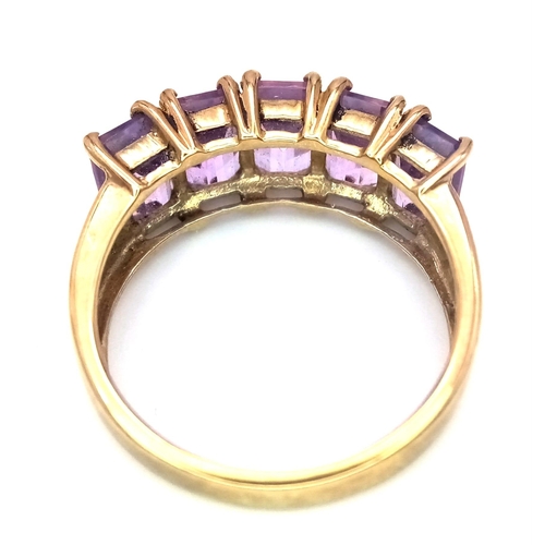 310 - A 9K GOLD RING WITH 5 AMETHYST STONES .  2.8gms   size L