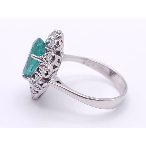 85 - An 18K White Gold Diamond and Emerald Ring. 1ct central teardrop emerald with a 1ctw brilliant round... 