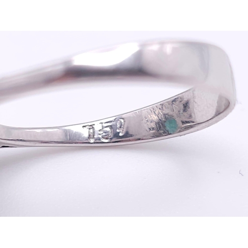 85 - An 18K White Gold Diamond and Emerald Ring. 1ct central teardrop emerald with a 1ctw brilliant round... 