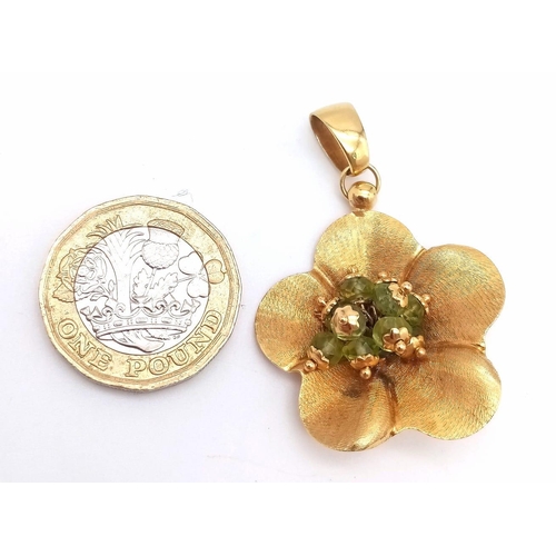 92 - An 18K Yellow Gold Peridot Flower Brooch. Nine peridots amongst golden petals. 5cm. 6.45g total weig... 