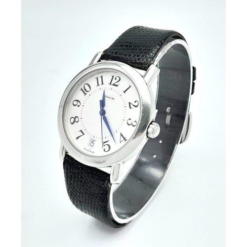 1144 - A Coach Quartz Gents Watch. Black leather strap. Stainless steel case. White dial. In working order.