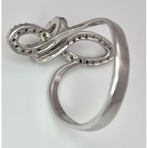 1079 - An 18K White Gold CZ Fancy Knot Ring. Size O. 3.9g weight.