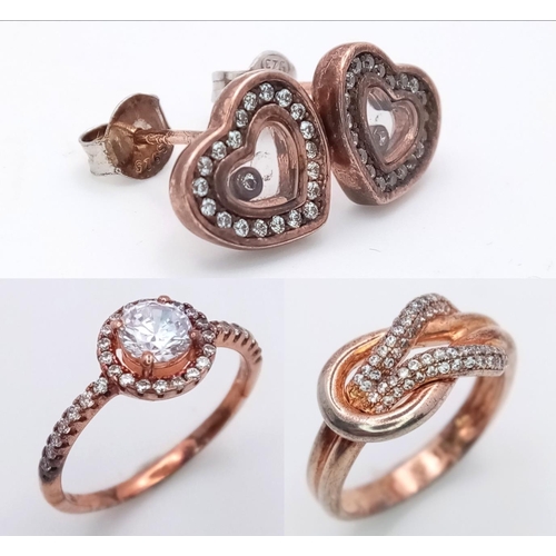 1065 - A sterling silver group of TWO rings and ONE pair of earrings, with rose gold vermeil finish and sto... 