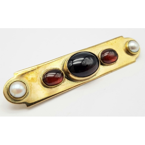 107 - AN EDWARDIAN 15K GOLD BAR BROOCH WITH SEED PEARLS , CARNELIAN AND CENTRAL GARNET  .  9.4gms   6cms w... 