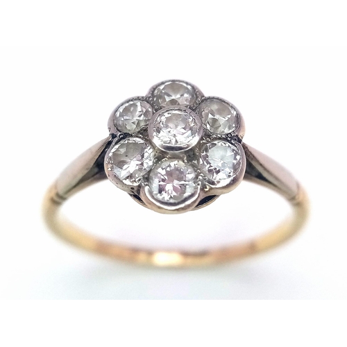 15 - A Vintage 18K Yellow Gold Diamond Ring. Seven round cut diamonds in a floral shape. Size P. 2.52g to... 