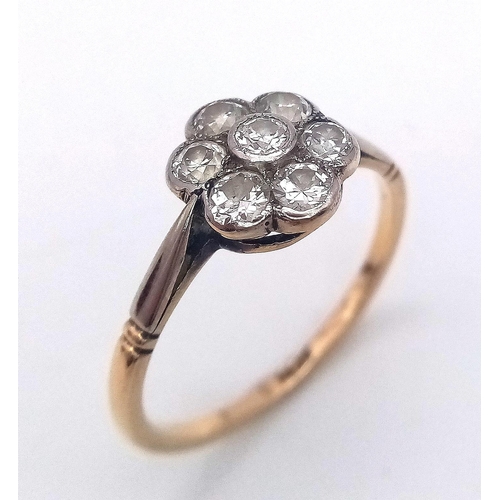 15 - A Vintage 18K Yellow Gold Diamond Ring. Seven round cut diamonds in a floral shape. Size P. 2.52g to... 