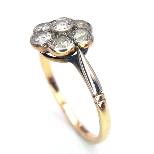 15 - A Vintage 18K Yellow Gold Diamond Ring. Seven round cut diamonds in a floral shape. Size P. 2.52g to... 