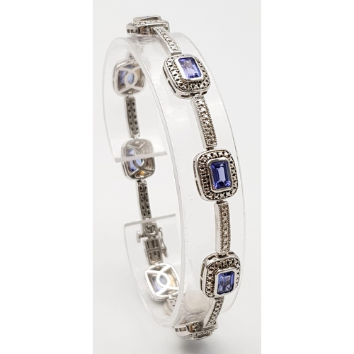 267 - An Exquisite Sterling Silver and Eight Rectangle Cut Tanzanite Set Bracelet. Complete with original ... 