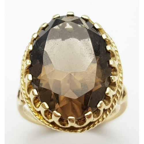 8 - A Vintage 9K Yellow Gold Smoky Quartz Ring. Large oval cut 10ct smoky quartz in a decorative setting... 