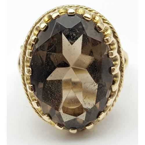 8 - A Vintage 9K Yellow Gold Smoky Quartz Ring. Large oval cut 10ct smoky quartz in a decorative setting... 