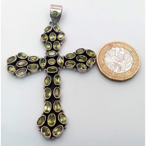 683 - A Sterling Silver and Peridot Set Cross Pendant 7.5cm Length. Set with 38 Peridots the Cross Measure... 