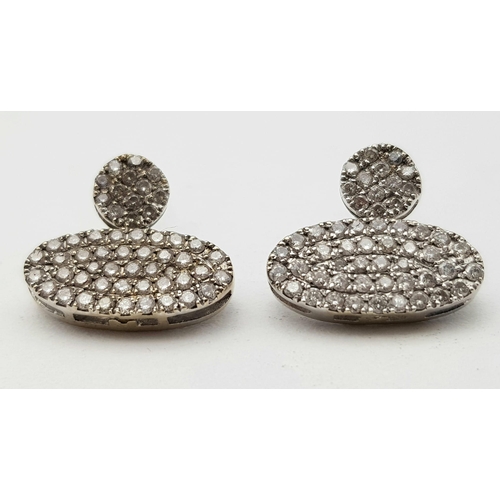 565 - A PAIR OF DIAMOND ENCRUSTED EARRINGS SET IN PLATINUM .  2.2gms