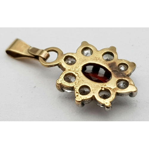 600 - A DIAMOND AND GARNET PENDANT SET IN 14K GOLD .   .7gms