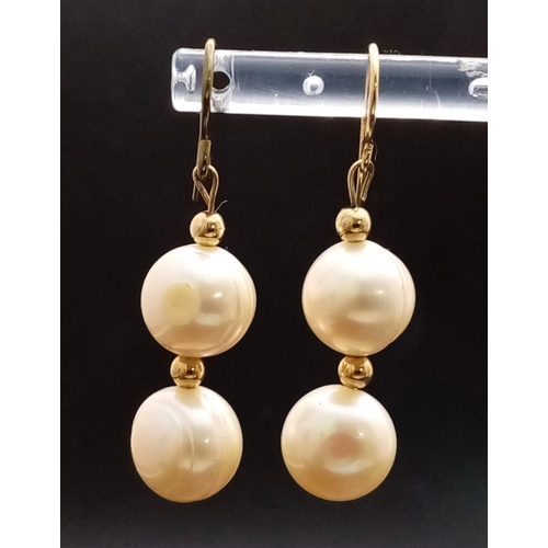 956 - A pair of fresh water pearl earrings. One earring appears to have a 14 K yellow gold hook. earrings ... 