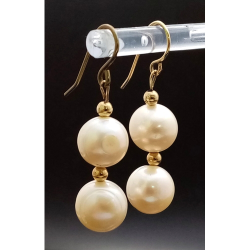 956 - A pair of fresh water pearl earrings. One earring appears to have a 14 K yellow gold hook. earrings ... 