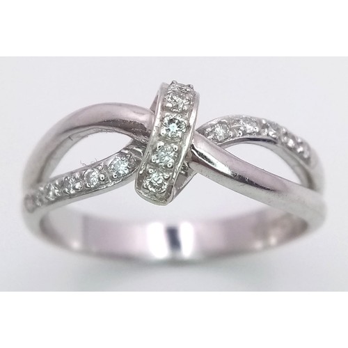 180 - A FANCY 18K WHITE GOLD DIAMOND KNOTTED RING, APPROX 0.15CT DIAMONDS, WEIGHT 3.8G SIZE N