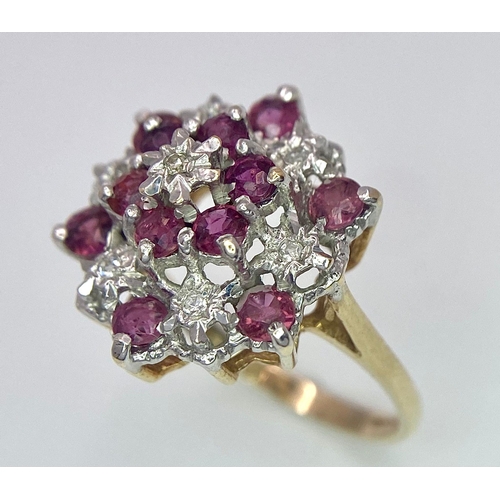 545 - AN ATTRACTIVE 9K YELLOW GOLD DIAMOND & RUBY CLUSTER RING, WEIGHT 3.5G SIZE O