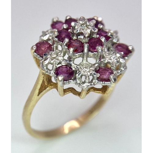 545 - AN ATTRACTIVE 9K YELLOW GOLD DIAMOND & RUBY CLUSTER RING, WEIGHT 3.5G SIZE O