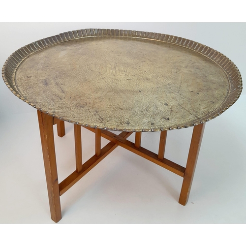 1028 - A MIDDLE EASTERN BRASS TOPPED TABLE WITH FOLDING WOODEN LEGS .   52cms TALL     76cms DIAMETER. Coll... 