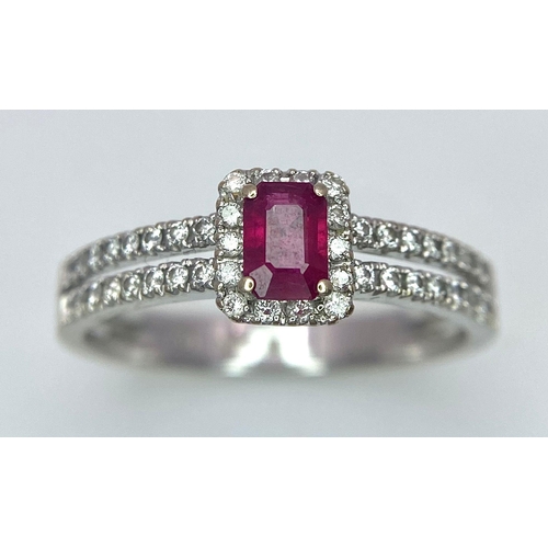 509 - 18K WHITE GOLD DIAMOND & RUBY RING, WITH A RECTANGULAR 0.30CT RUBY AND DECORATED BY A HALO DIAMONDS ... 