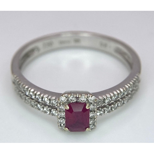 509 - 18K WHITE GOLD DIAMOND & RUBY RING, WITH A RECTANGULAR 0.30CT RUBY AND DECORATED BY A HALO DIAMONDS ... 