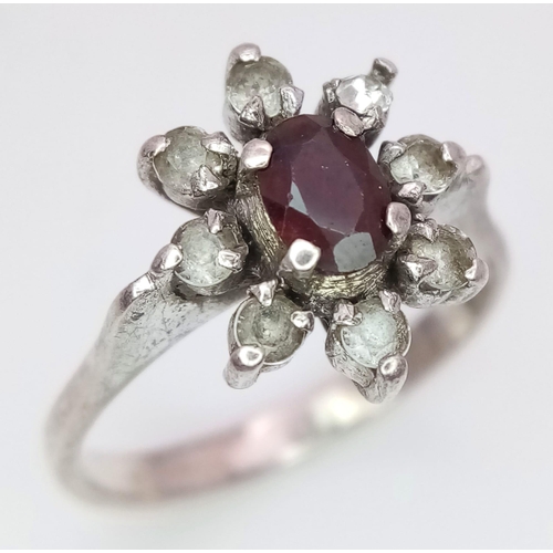 799 - A fancy 925 silver Zirconia and Garnet floral cluster ring. Total weight 2.5G. Size K.