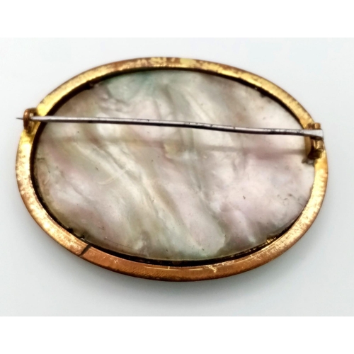 646 - An Antique Bronze, Brass and Mother of Pearl Brooch. Brass and mop foundations with a decorative rel... 