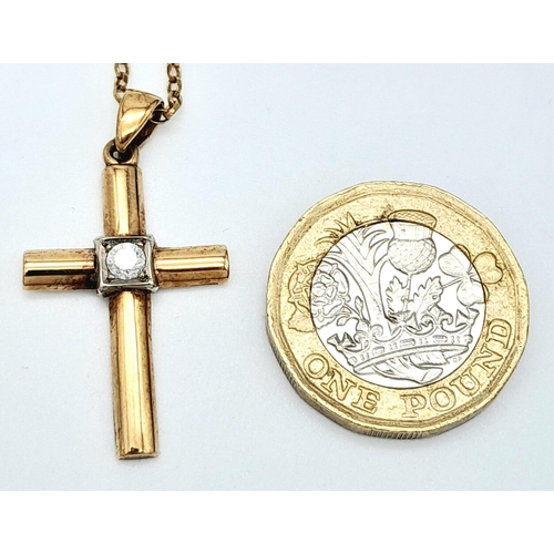 656 - A 9 K yellow cross with a single round cut diamond on a 41 cm long 9 K gold chain. Cross dimensions:... 