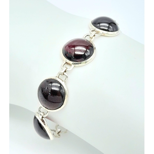 802 - A Sterling Silver Red Stone Cabochon Set Bracelet. 19cm Length. 1.3cm Width. Gross Weight 12.75 Gram... 