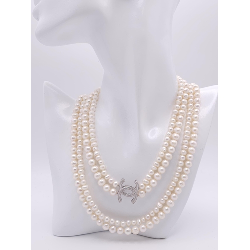 592 - A Two Row Cultured Pearl Necklace with Sterling Silver and White Stone Clasp. 80cm length.