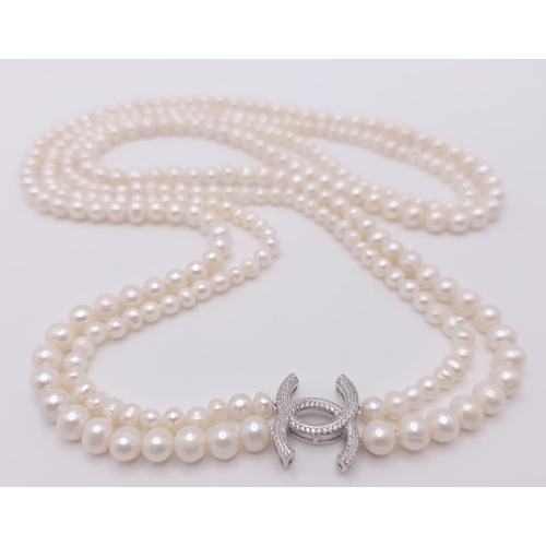 592 - A Two Row Cultured Pearl Necklace with Sterling Silver and White Stone Clasp. 80cm length.