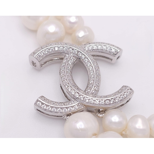 592 - A Two Row Cultured Pearl Necklace with Sterling Silver and White Stone Clasp. 80cm length.