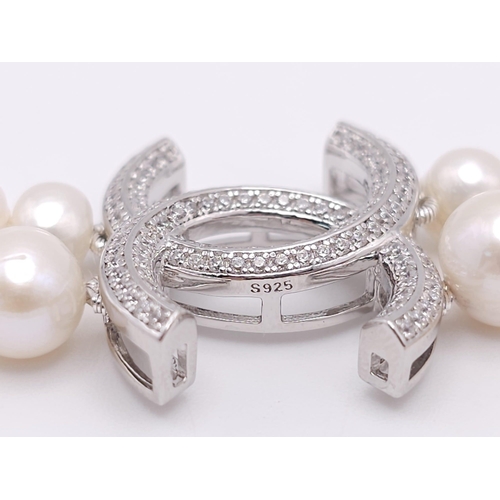 592 - A Two Row Cultured Pearl Necklace with Sterling Silver and White Stone Clasp. 80cm length.