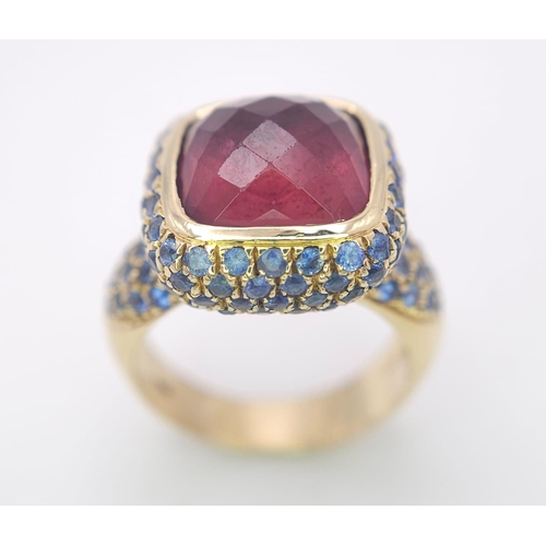 902 - An 18K Yellow Gold Red Tourmaline and Sapphire Ring. A well faceted central tourmaline with a sapphi... 