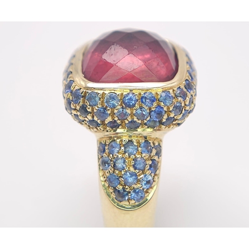 902 - An 18K Yellow Gold Red Tourmaline and Sapphire Ring. A well faceted central tourmaline with a sapphi... 