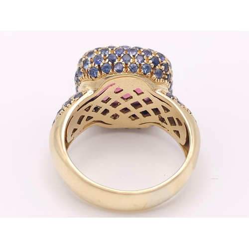 902 - An 18K Yellow Gold Red Tourmaline and Sapphire Ring. A well faceted central tourmaline with a sapphi... 