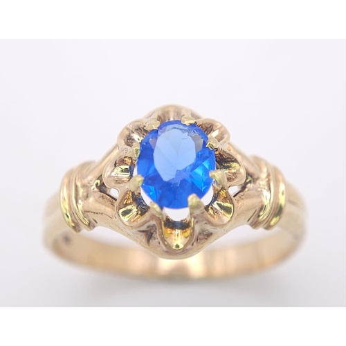 974 - An 18K Yellow Gold and Blue Topaz Ring. Stunning central oval cut topaz. Size P. 3.5g total weight.