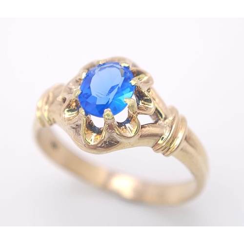 974 - An 18K Yellow Gold and Blue Topaz Ring. Stunning central oval cut topaz. Size P. 3.5g total weight.