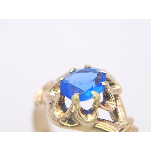 974 - An 18K Yellow Gold and Blue Topaz Ring. Stunning central oval cut topaz. Size P. 3.5g total weight.