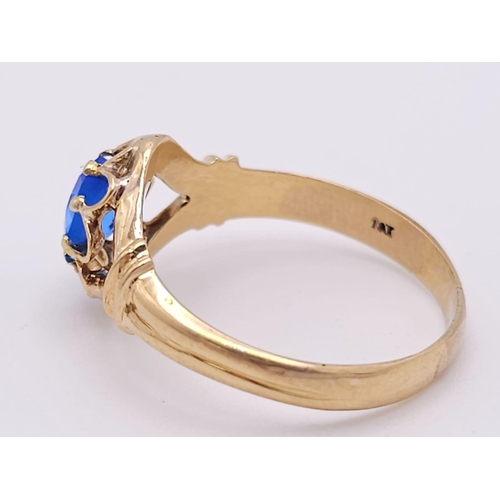 974 - An 18K Yellow Gold and Blue Topaz Ring. Stunning central oval cut topaz. Size P. 3.5g total weight.