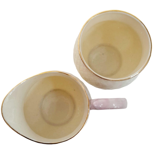 1390 - A rare Irish Belleek sugar bowl and creamer. Cream colour with pink lips and gold ring on top,