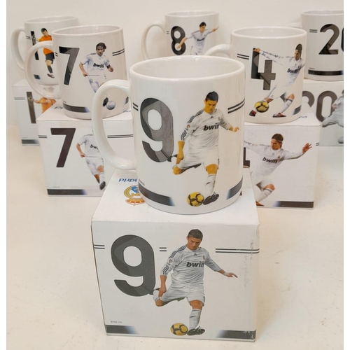 606 - A Collection of Eleven Real Madrid Mugs - Each decorated with a different player. As new, in boxes. ... 