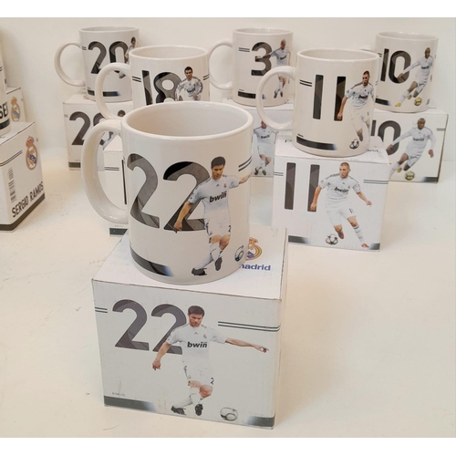 606 - A Collection of Eleven Real Madrid Mugs - Each decorated with a different player. As new, in boxes. ... 