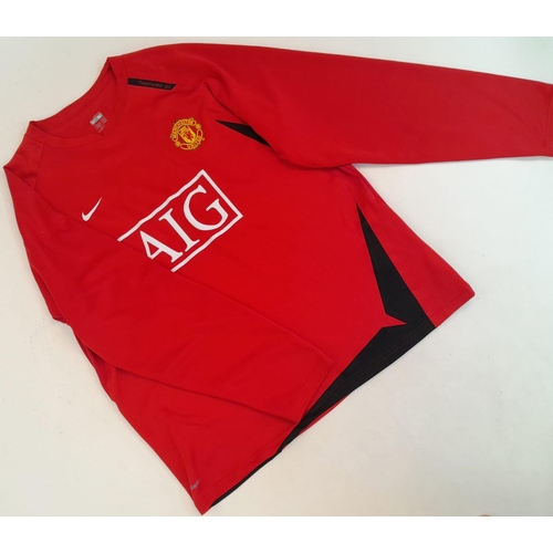 709 - A Collection of Manchester United Clothing: Nike Red Shirt - AIG (XL), Scarf, Xmas Hat, Beenie hat a... 