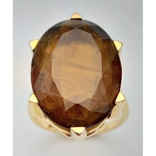 771 - A 9K Yellow Gold (tested) Smoky Quartz Ring. 12ct central oval smoky quartz. 6.73g total weight. Siz... 