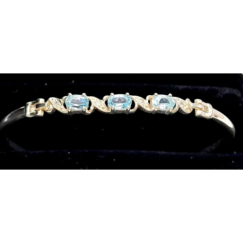 774 - A Sterling Silver Aquamarine Set Bracelet. 6.5cm Inner Width. Set with three 6mm Oval Cut Aquamarine... 