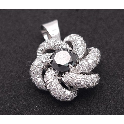 930 - An 18K White Gold, Black and White Diamond Decorative Floral Pendant. 25mm. 4.65g weight.